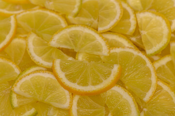Bright slices of fresh lemons arranged artistically on a vibrant yellow background