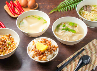 Braised Rice and Minced Pork, Minced Pork Dry Noodles, Wontons Soup, Crystal Dumplings Soup, Beef Noodle, served in bowls with chopsticks and spoon isolated on wooden table side view of Taiwan food