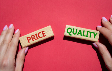 Price and Quality symbol. Concept word Price and Quality on wooden blocks. Businessman hand. Beautiful red background. Business and Price and Quality concept. Copy space