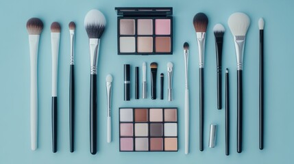 Top view of collection of makeup brushes, powder and eyeshadow palettes on blue background.