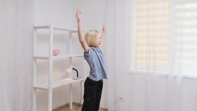 Young boy doing arm stretching exercise in slow motion, showcasing flexibility in a home setting