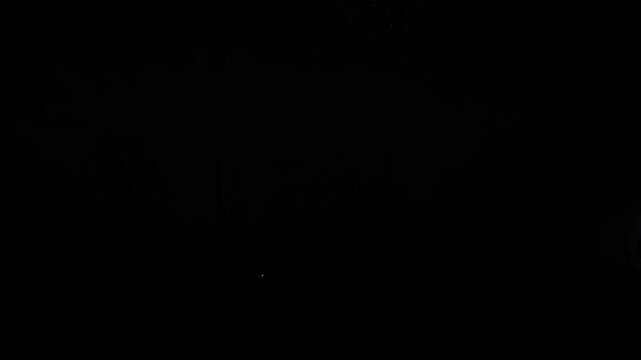 Golden purple green sparks scattering fireworks on the black night sky. General plan