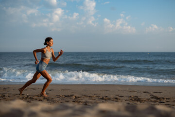 Fit Woman Running Along the Beach in the Morning