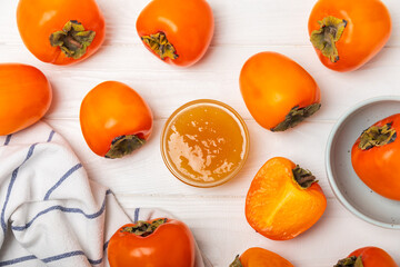 Persimmon jam with slices of ripe persimmon on wooden textured table. Delicious persimmon jam. Marmalade. Healthy sweets. Vegan. Close-up. Space for text. Copy space.