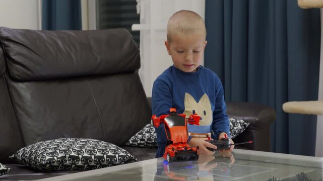 Impatient child unboxing new toy at home. Excited little boy unpacks remote-controlled transformer car.