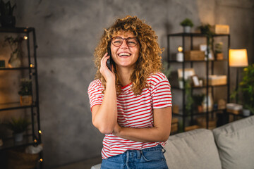 adult young woman smile and talk on mobile phone at home