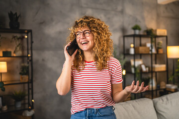 adult young woman smile and talk on mobile phone at home