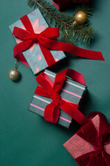 Beautiful Christmas background flat lay with gifts on green with red  ribbons and pine branches