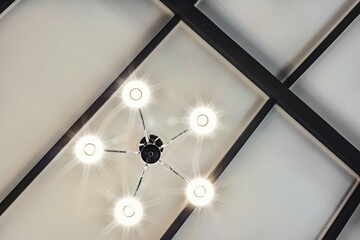 interior of a house looking up at the ceiling showing a decorative lampshade chandelier 