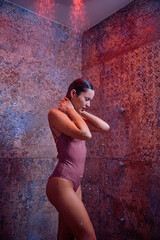 Beautiful woman under the shower in Turkish bath.