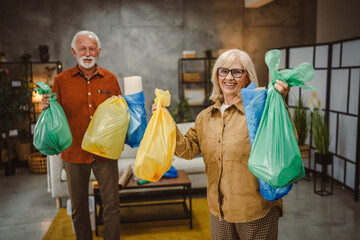 Portrait of senior husband and wife stand with plastic bags recycle