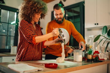 Couple making dough in kitchen using stand mixer
