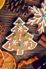 christmas baked gingerbread snowflakes cookies with evergreen twigs on wood, color of the year 2025 mocha mousse
