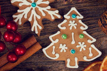 christmas baked gingerbread snowflakes cookies with evergreen twigs on wood, color of the year 2025 mocha mousse