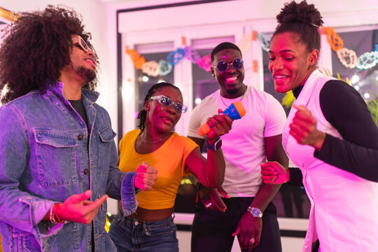 Happy friends singing karaoke at home party - Powered by Adobe