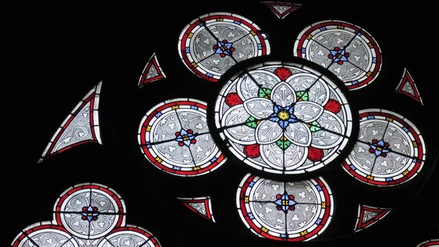Stunning stained glass window illuminating Notre Dame Cathedral in Paris with vibrant hues and detailed patterns
