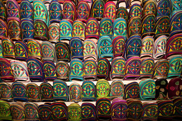 Venta de zapatillas de colores con bordados en el zoco de Marrakech, Marruecos.	