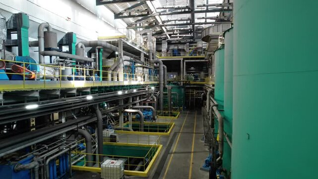 Spacious factory hall with cardboard production facilities. Mechanisms provide full transformation of paper pulp into finished material