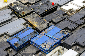 Stack of many used car lead batteries for recycling in a hazardous waste facility