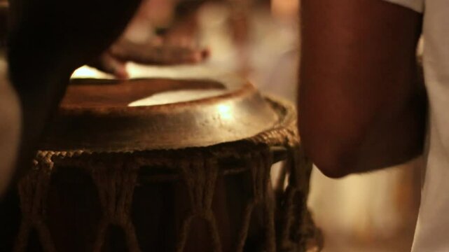 detail of hands playing leather timbal, percussion instrument in capoeira circle. man playing atabaque