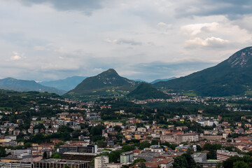 Breathtaking aerial view of city of Trento nestled amidst cloud covered mountainous landscape in Trentino Alto Adige, Italy. Vantage point from Terrazza Panoramica Busa Degli Orsi. Tourist destination