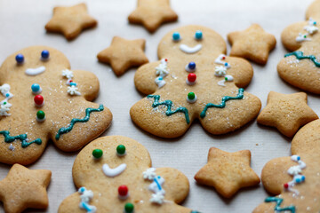 A small decorated Christmas gingerbread man surrounded by other sweets. Christmas baking