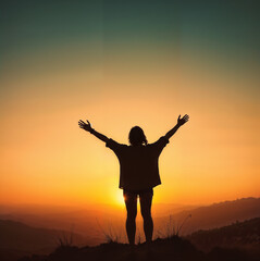 Fototapeta premium Silhouette of a joyful woman with outstretched arms celebrating at sunset in a mountain landscape for International Women's Day