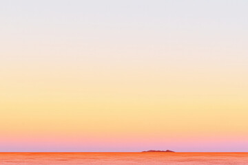 Fototapeta premium serene landscape featuring soft gradient of orange and pink hues transitioning into pale sky, evoking tranquility and calmness