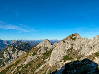 Summit of mount Due Pizzi Cima Alta surrounded by rugged mountain peaks of Dolomites, Carnic Alps and Julian Alps. Hiking trail to mount Piper in Friuli Venezia Giulia, Italy. Wanderlust Italian Alps