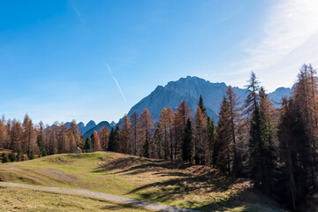 Scenic hiking path through alpine meadow with view of majestic mountains peaks Julian Alps in...