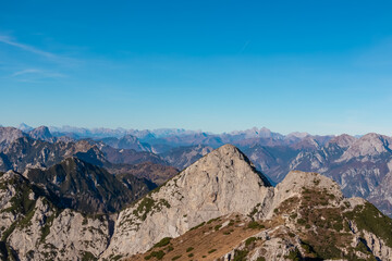 Fototapeta premium Summit of mount Due Pizzi Cima Alta surrounded by rugged mountain peaks of Dolomites, Carnic Alps and Julian Alps. Hiking trail to mount Piper in Friuli Venezia Giulia, Italy. Wanderlust Italian Alps