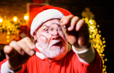 Santa Claus with glasses in his hands. Selective focus. Christmas time. Bearded man in Santa hat...