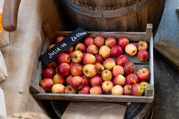 Red apples, Julia UK variety, £4.50 per kilogram, displayed in a wooden crate for sale.