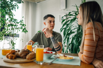 Lesbian couple having breakfast and talking at home
