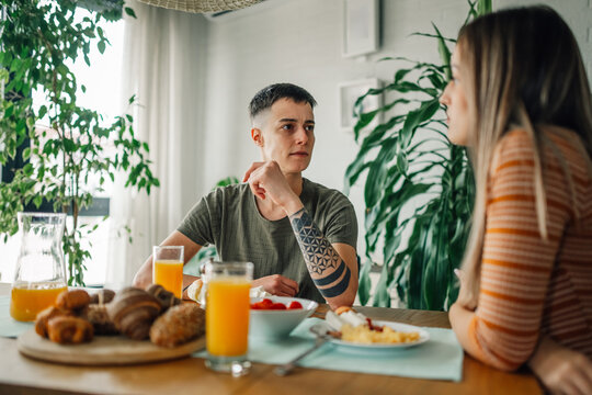 Lesbian couple having breakfast and talking at home