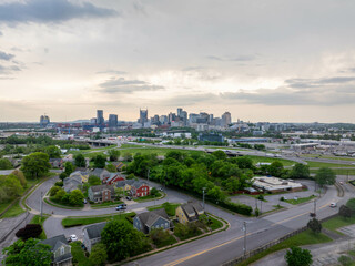 Dusk in Nashville, a growing skyline above a green neighborhood with low houses create an urban view of this American city in Tennessee