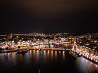 Stunning nighttime cityscape of Geneva, Switzerland with city lights reflected on rhone river and Lake Geneva, illuminated buildings, bridges, and urban life