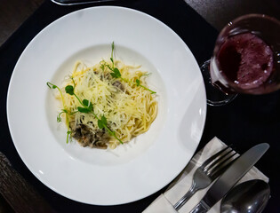 Traditional Italian creamy mushroom pasta with cheese garnished with fresh microgreens