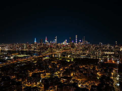 Illuminated Queensboro Bridge connecting Manhattan and Queens, part of the stunning New York City skyline glowing at night