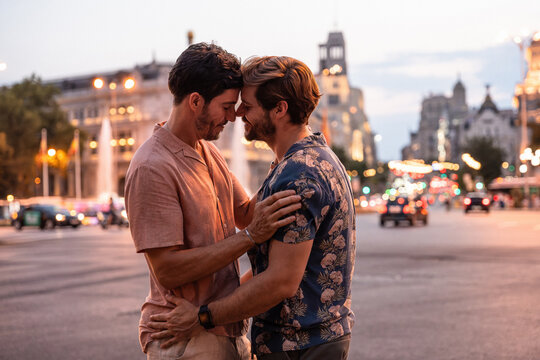 Tender moment between a gay couple in a city at dusk