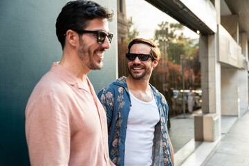 Gay couple smiling and walking in urban setting