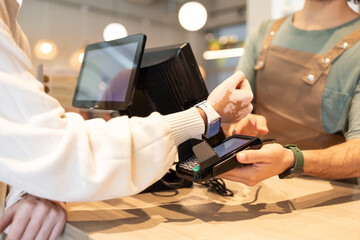 Cafe worker assisting customer with contactless payment