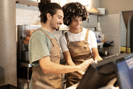 Cafe workers collaborating at the counter with a smile