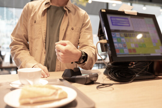 Customer Making Contactless Payment at Cafe Counter