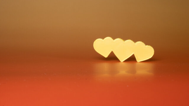 Polyamory concept, three hearts united on a red background