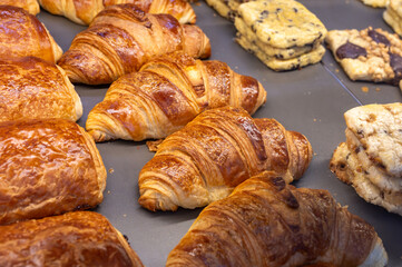 Fresh baked buttered croissants and sweet buns, pastries in village bakery in France