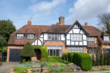 Walking on streets of North London, red brick houses and flowering gardens in spring, city life, wealthy neighbourhoods in London, UK