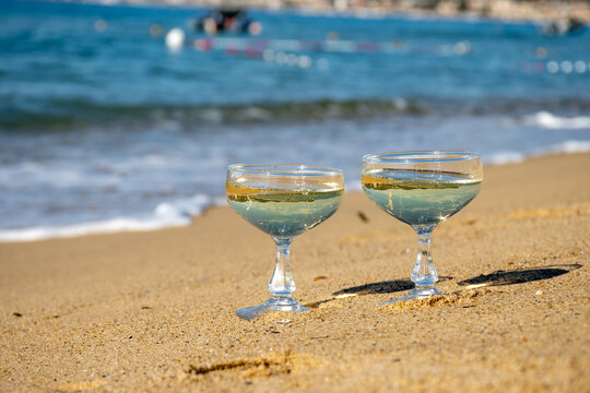 Summer time on French Riviera, two coupe glasses of champagne cremant sparkling wine on Pampelonne sandy beach near Saint-Tropez in sunny day, Var, vacation in France - Powered by Adobe