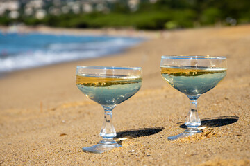 Summer time on French Riviera, two coupe glasses of champagne cremant sparkling wine on Pampelonne sandy beach near Saint-Tropez in sunny day, Var, vacation in France
