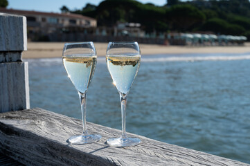 Summer time in Provence, two glasses of cold champagne cremant sparkling wine on famous Pampelonne sandy beach near Saint-Tropez in sunny day, Var department, France, beach club party